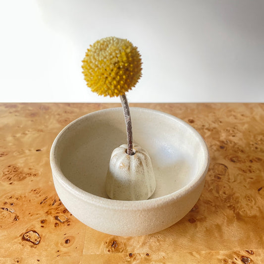 Two piece vase in cream color with a single stem flower with round yellow tip