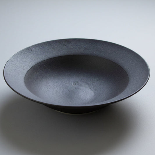 Black ceramic bowl on a light gray background
