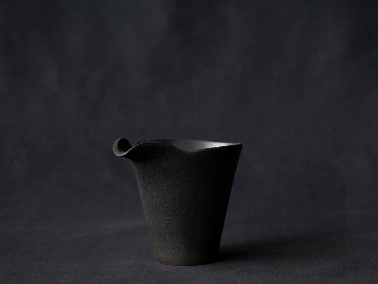 black ceramic carafe with front view of spout