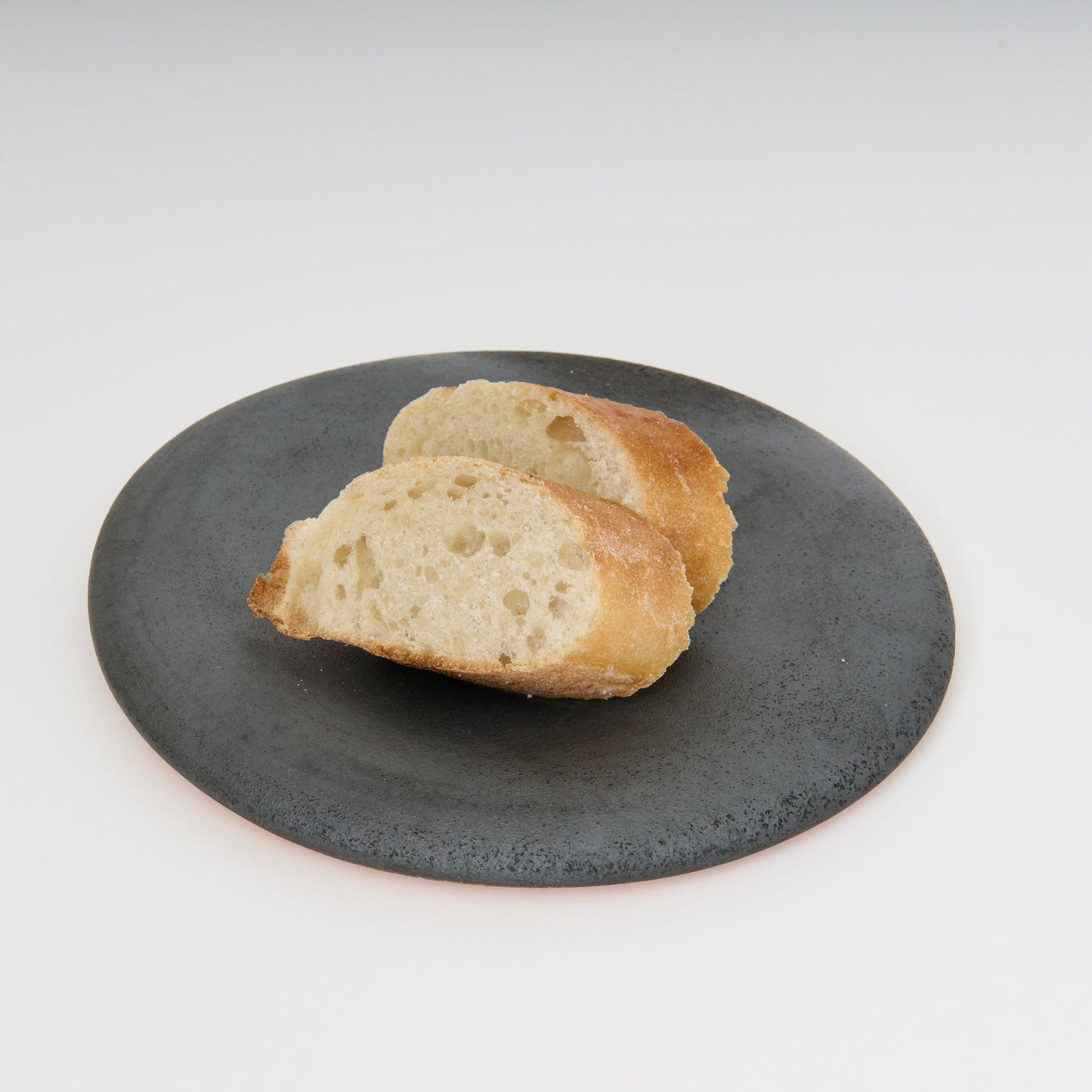 black round ceramic plate with two pieces of bread on top