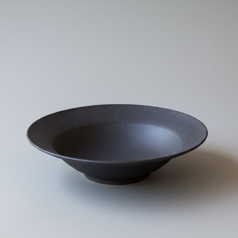 Black ceramic bowl on a light gray background