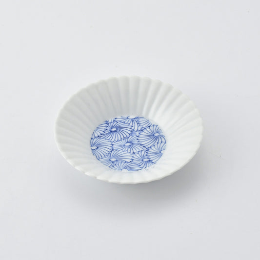 White ceramic fluted dish with blue floral pattern on a white background