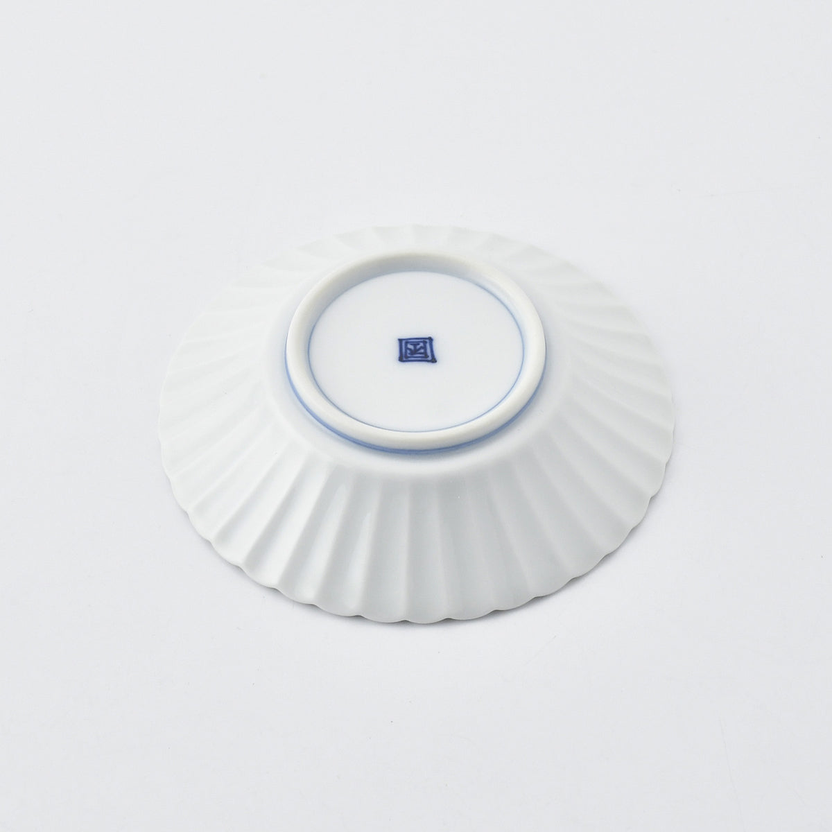 Bottom of a white ceramic fluted dish with logo on a white background