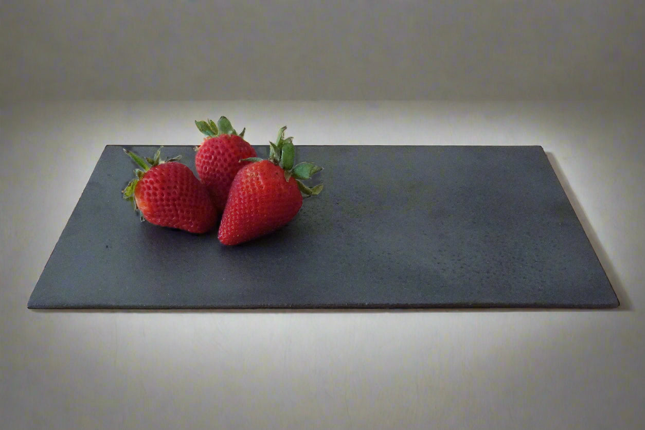 three strawberries on black rectangular ceramic plate