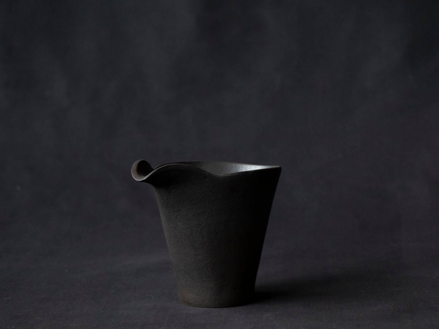 black ceramic carafe with front view of spout