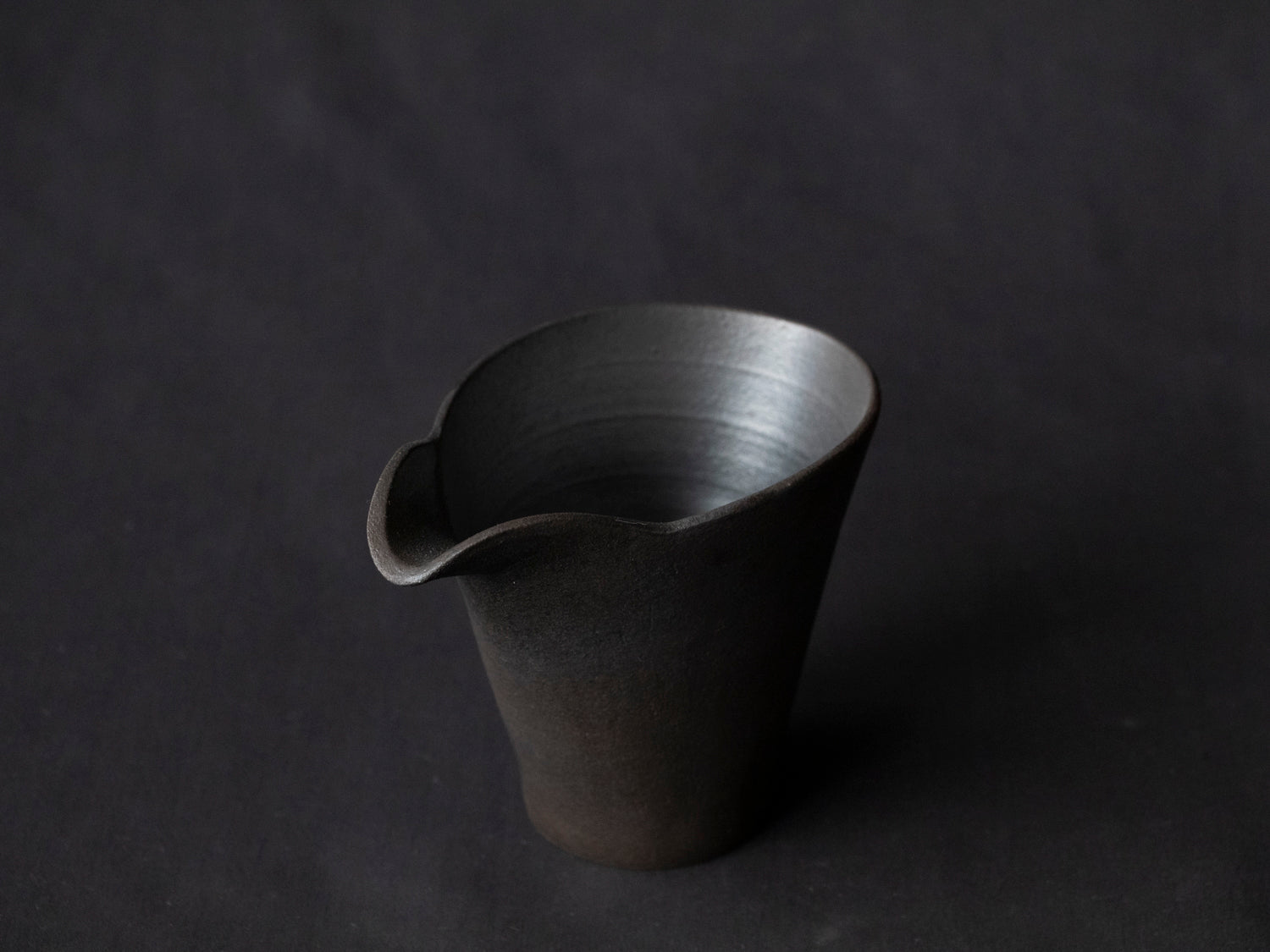 black ceramic carafe with spout from above 