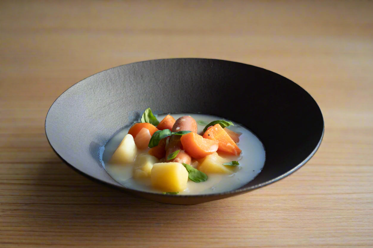 Pot-au-feu in a black ceramic wide bowl