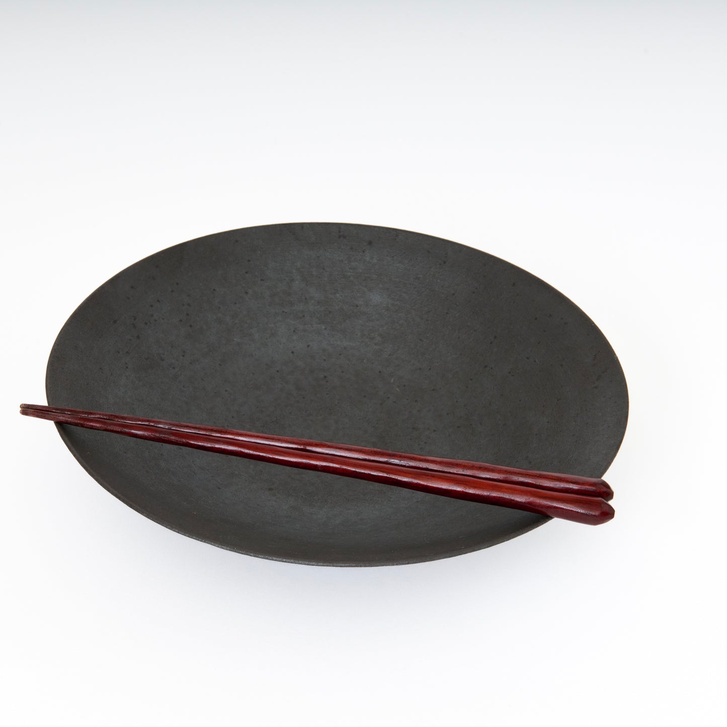 black ceramic wide bowl with chopsticks