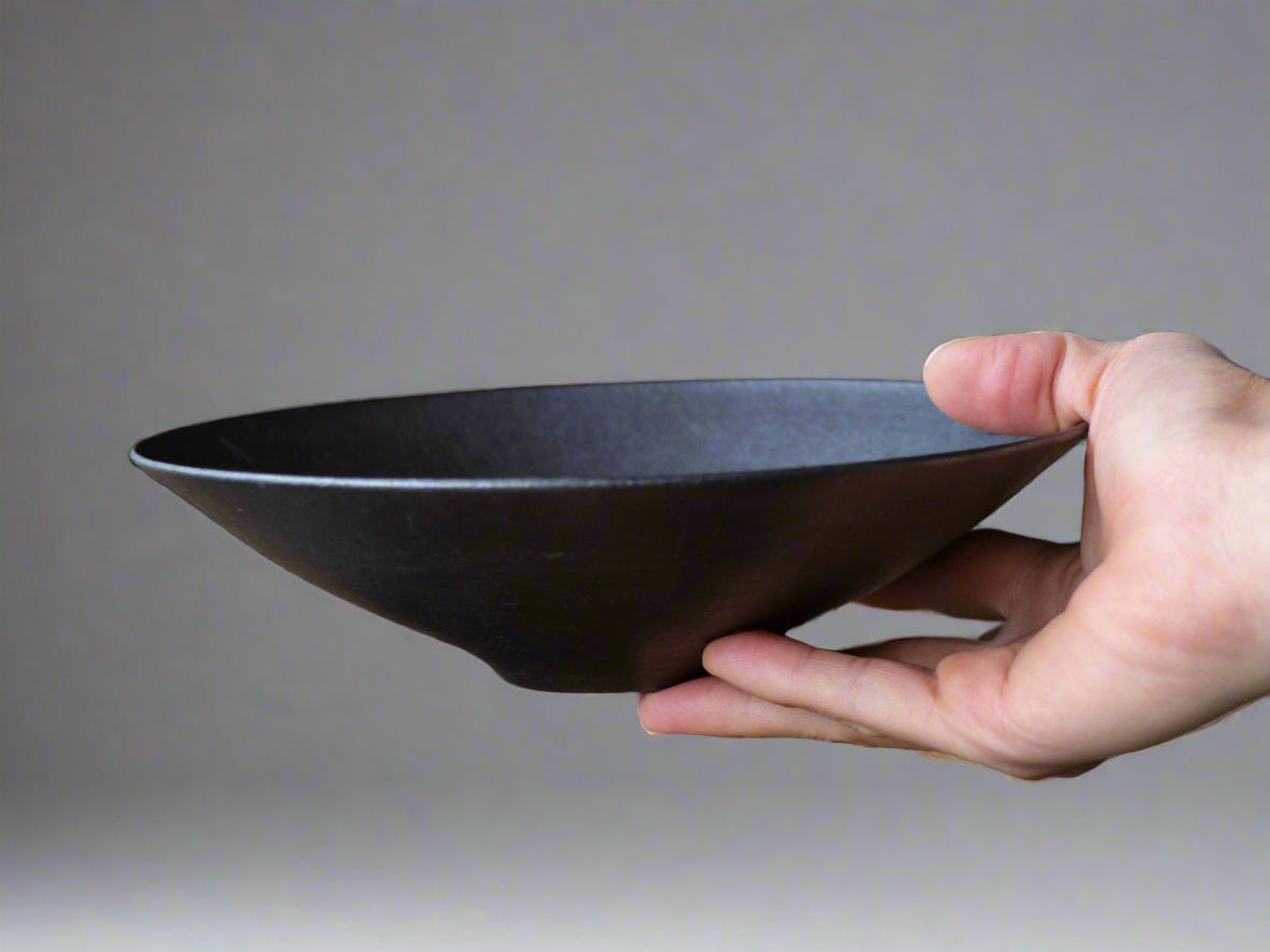 hand held black ceramic wide bowl